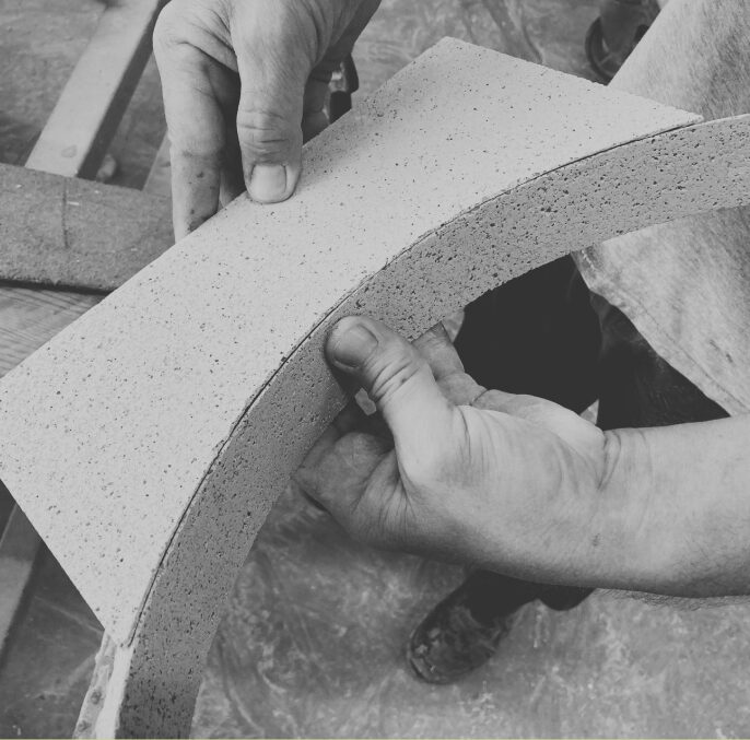 Manipulation manuelle d’une dalle minérale en cours de fabrication.