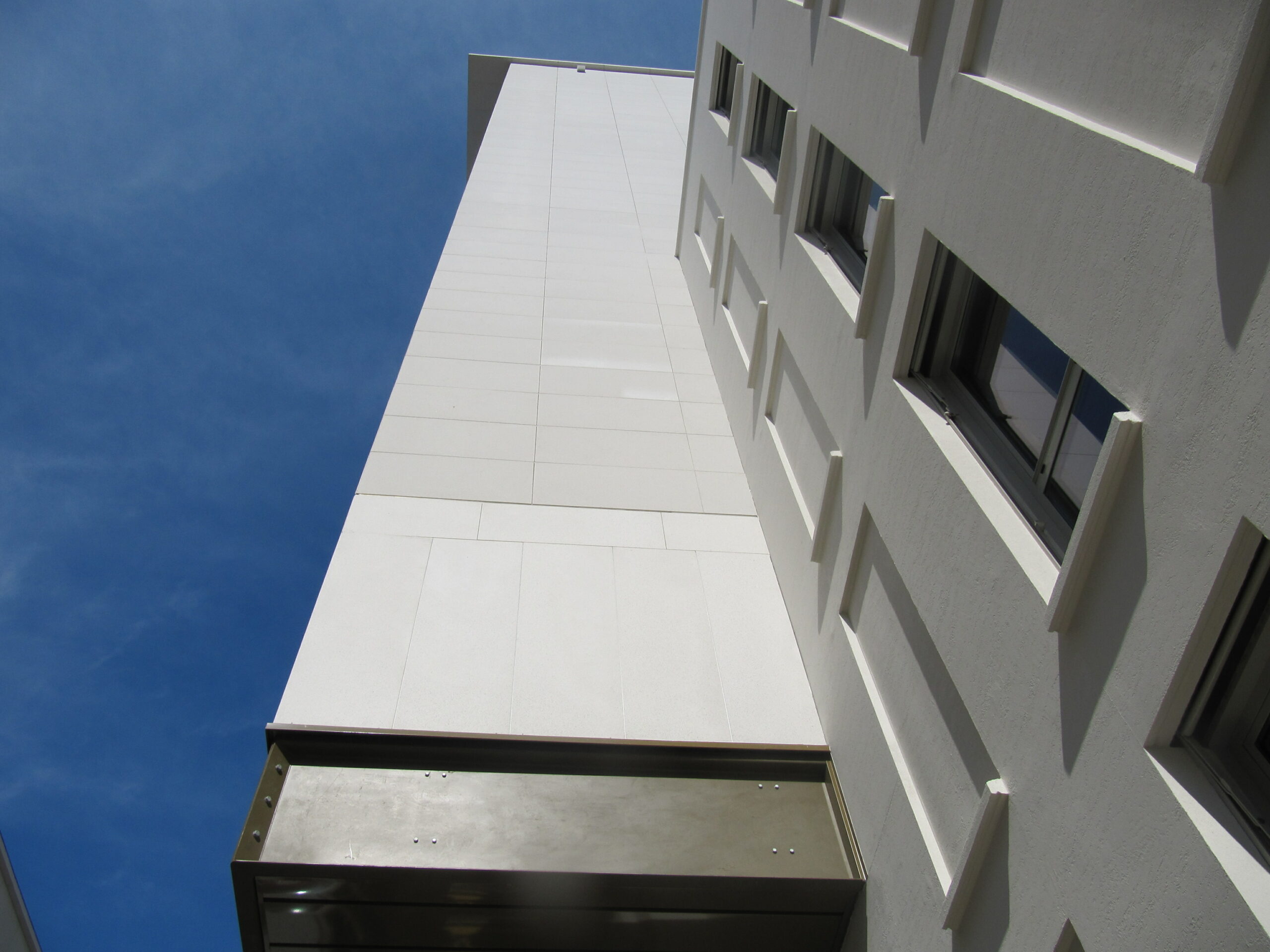 Façade extérieure habillée de dalles minérales Rebeton – vue en contre-plongée.