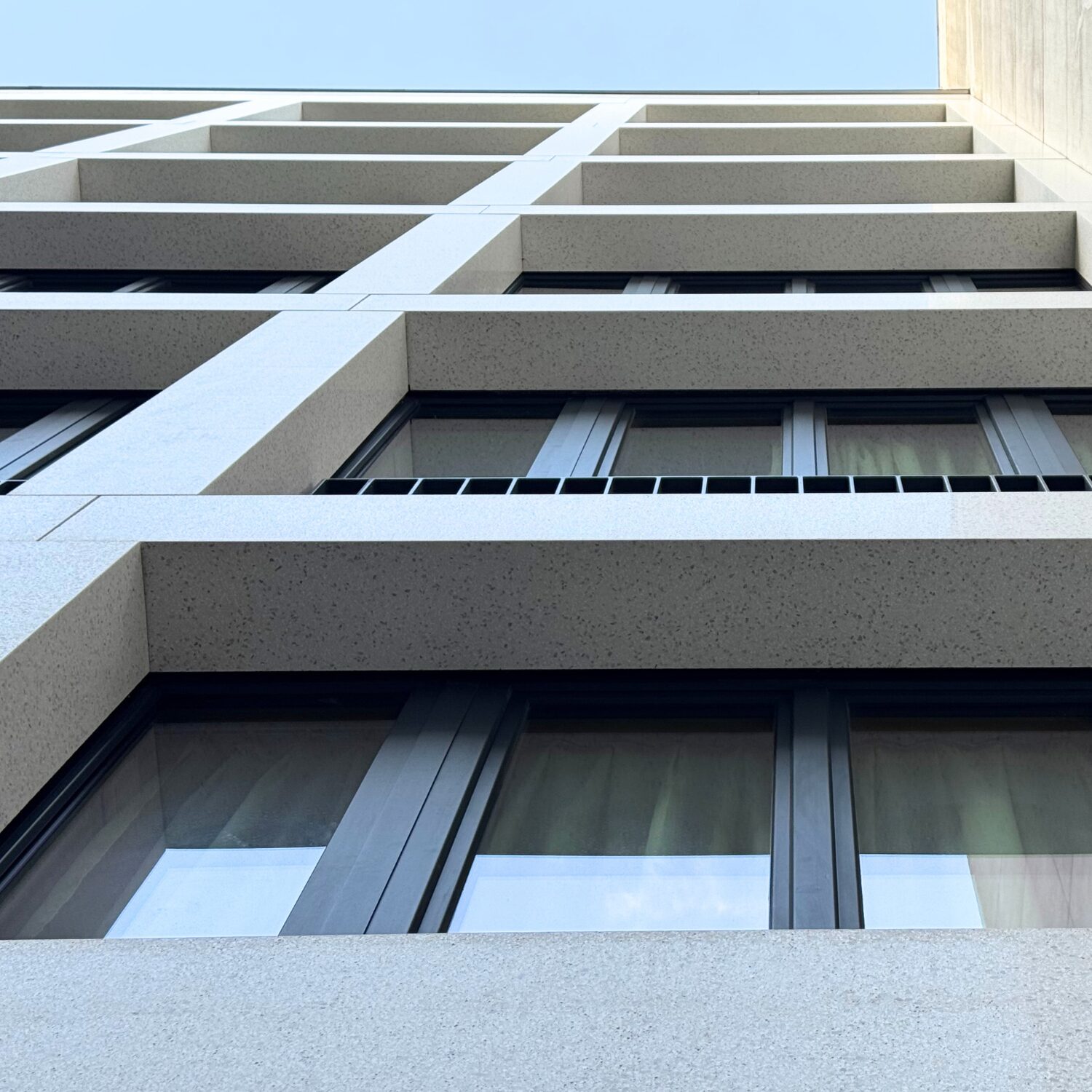 Façade du projet Edgar Suite en dalles minérales sur mesure Rebeton.